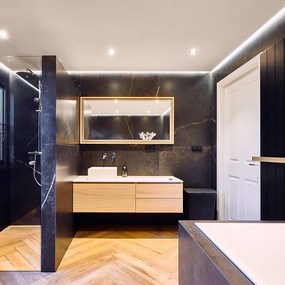 Modernes Badezimmer mit dunklen Fliesen, Holzwaschtisch, großer Dusche und Badewanne.